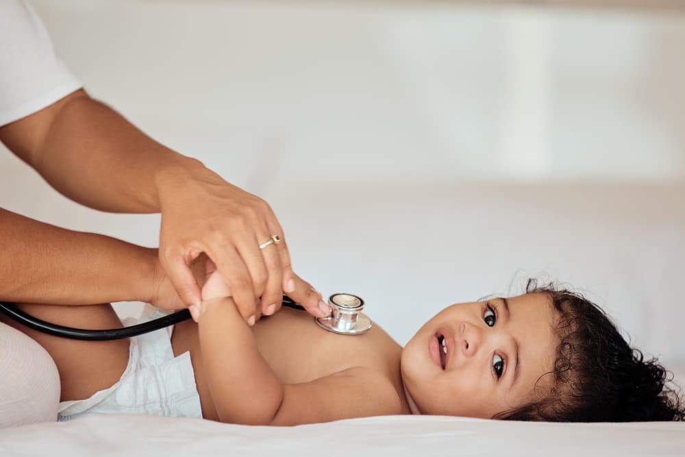 Therapist performing gentle Shiro Abhyanga on a young child during paediatric Panchakarma.
