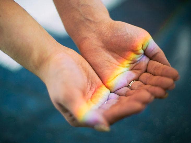Colour-infused water bottles set out in sunlight.