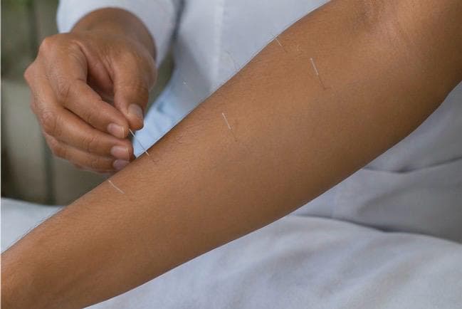 Acupressure point charts being referred to during a session.